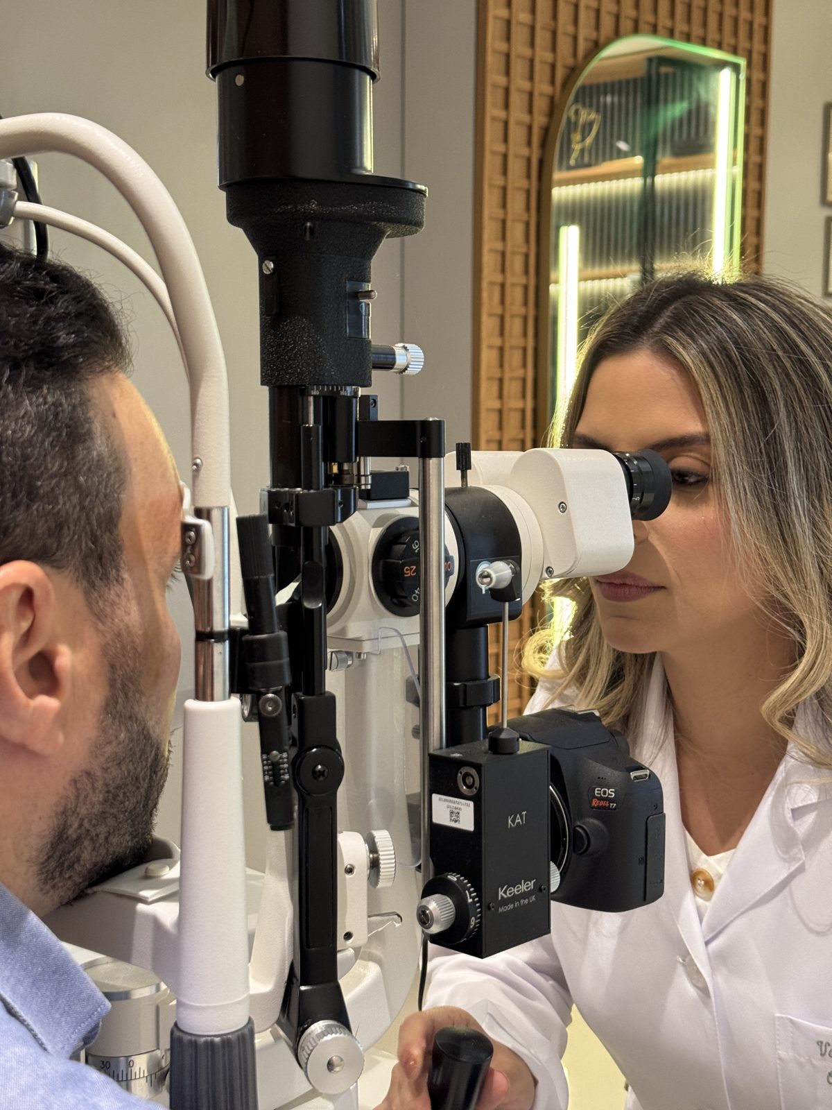 Dra. Vanessa realizando exame com equipamento oftalmológico